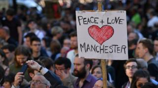 Sign saying Peace + Love Manchester being held at the Manchester attack vigil last year
