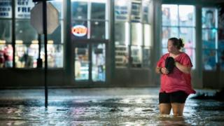 A woman walks through floodwaters in Myrtle Beach, South Carolina on 3 August