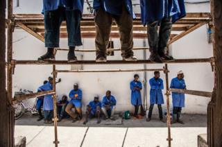 Students working on a damaged doorway Wanafunzi wakiukarabati mlango