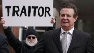 Манафорт і протестуючий позаду нього з плакатом "Зрадник"