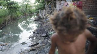 Esgoto e criança em favela
