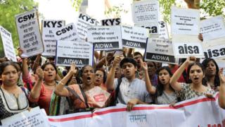 Indian activists hold placards that read in Hindi 