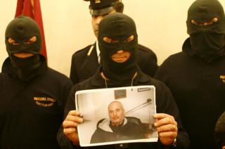 Офицеры Каттуранди показывают фотографию босса мафии Доменико Раккулья