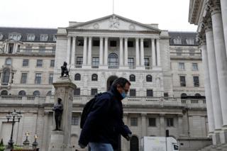 A man walks past the Bank of England in London