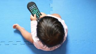 baby holding a TV remote