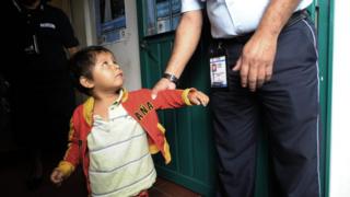 Una niña es tomada por un oficial de migración en México