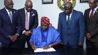 Awọoran Ambode lasiko ti o n tọwọ bọ iwe