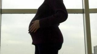беременная женщина перед окном