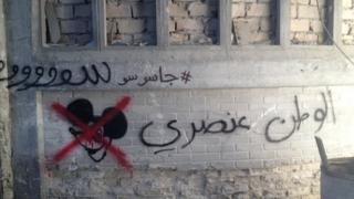 Graffiti reading "Homeland is racist" on the set