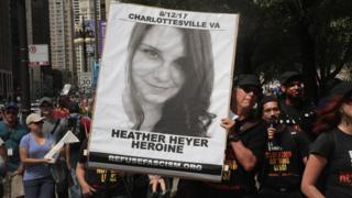 A demonstrator carries a sign remembering Heather Heyer during a protest on August 13, 2017 in Chicago, Illinois