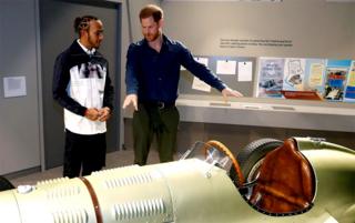 Prince Harry and Formula One world champion driver Lewis Hamilton look at a car
