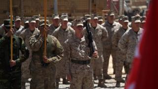 Солдаты морской пехоты США и Афганской национальной армии (АНА) несут флаги во время церемонии передачи в лагере Лезернек в Лашкар-Га в афганской провинции Гильменд 29 апреля 2017 года