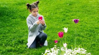girl-taking-pictures-of-flowers.