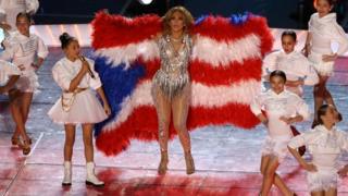 Jennifer López con la bandera de Puerto Rico y su hija.