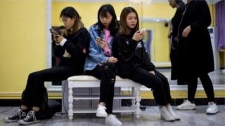 women looking at phones