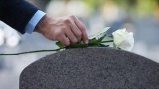 ኣብ ልዕሊ መቓብር ዕምበባ ዘቐምጥ ሰብ