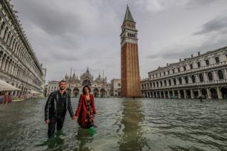 Personas en la Plaza de San Marcos inundada.