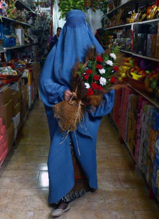 Qo'lida gul tutgan afg'on ayoli