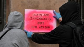 Activists stencil a slogan reading 