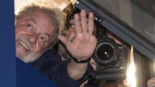 Forrmer Brazilian president Luis Inácio Lula da Silva waves to supporters from a window