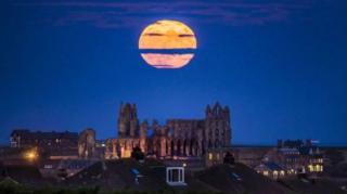 ซูเปอร์ฟูลมูนดวงกลมโตลอยเด่นเหนือวิหารวิตบี (Whitby Abbey) ในมณฑลยอร์กเชียร์