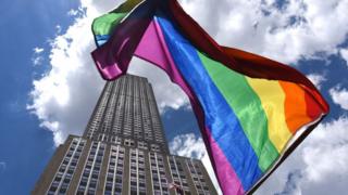 Pride flag waving in front of an office building