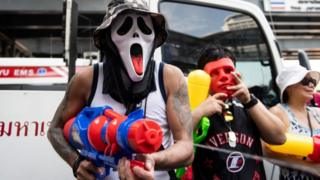 Mshiriki akitumia bunduki ya maji kuadhimisha mwaka wa kibudha , unaofahamika nchini humo kama Songkran, mjini Bangkok tarehe 13 Aprili 2019.