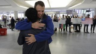 Капитан армии Мэтью Болл (R) обнимает своего бывшего переводчика Кисмата Амина в международном аэропорту Сан-Франциско.