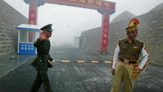 A Chinese soldier and an Indian soldier stand guard at the Chinese side of the ancient Nathu La border crossing between India and China in 2008