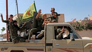 Kurdish Popular Protection Units (YPG) fighters parade through the northern Syrian town of Tal Abyad (23 June 2015)