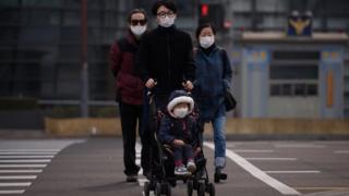 Корейская семья с маленьким ребенком, все в масках