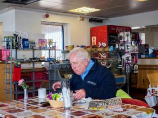 A man eats a Flo's cafe