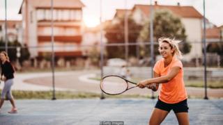Perempuan bermain tennis
