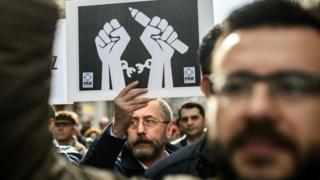 Журналисты выкрикивают лозунги и держат плакаты 10 января 2016 года, протестуя против заключения журналистов в тюрьму