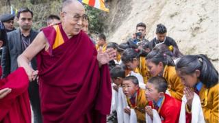 В раздаточном материале, предоставленном Тензином Чейджором, в офисе Далай-ламы показано, что последователи приветствуют тибетского духовного лидера,