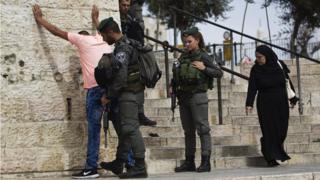 Israeli border policemen perform a security check on a Palestinian youth at Damascus Gate just outside Jerusalem's Old City before Friday prayers on 23 October 2015