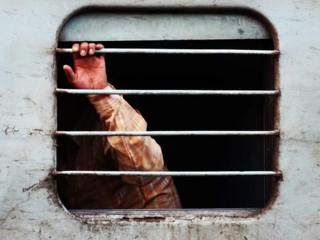Una mano sale por la ventana de un tren