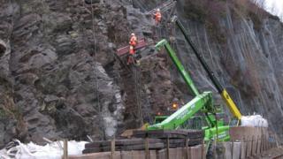Obair air a' chreig os cionn an rathaid a th' ann