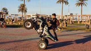 A Libyan boy performs a wheel-stand manoeuvre with an all-terrain vehicle at a park in the capital Tripoli on 31 January 2020