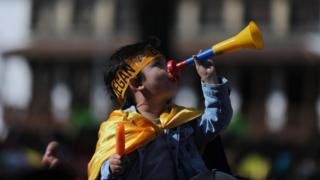 A child plays a vuvuzela at the homecoming party for Egan Bernal