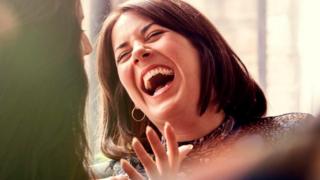 Una mujer riendo a mandíbula batiente