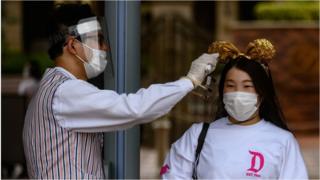 a visitor to Disneyland Japan has her temperature checked