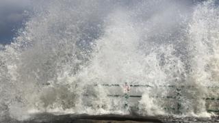 Water breaking over pier