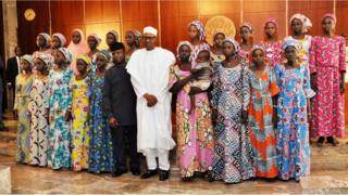 Le président nigérian Muhammadu Buhari se fait photographier ici avec une vingtaine de filles libérées par Boko Haram, en octobre 2016, à Abuja.