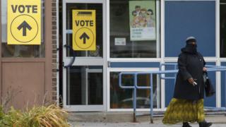 A woman wearing a niqab leaves a polling station during the Canadian elections
