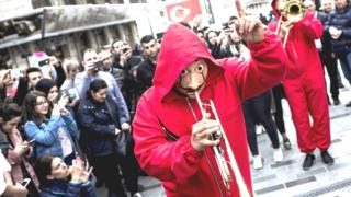Foto de manifestantes vestidos con los trajes de la serie "Casa de Papel".