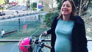 Julie Genter poses wit her bike outside di hospital