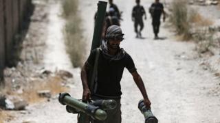 A fighter from the rebel Free Syrian Army walks towards the frontline in the Damascus suburb of Jobar (27 July 2015)