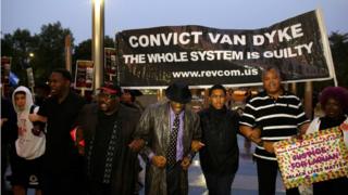 Protesters with sign saying CONVICT VAN DYKE