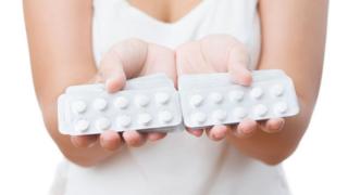 Mujer con pastillas de paracetamol